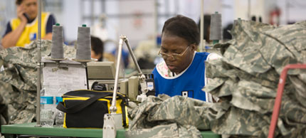 Photo of woman sewing military uniforms.